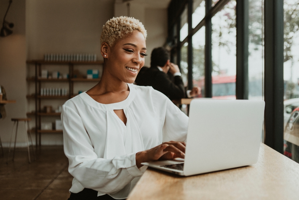 Femme confiante et souriante sur ordinateur portable